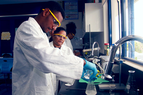 Diploma student doing an experiment under the guidance of his teacher.